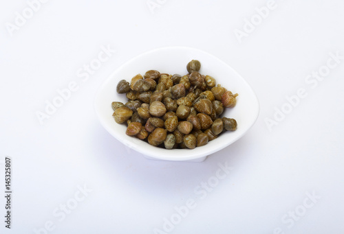 bowl with fresh capers isolated on white background.