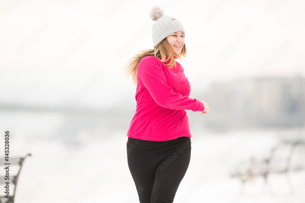 Pretty girl wearing sportswear and running on snow during winter Stock  Photo | Adobe Stock