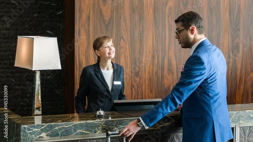 Attractive businessman registering at reception