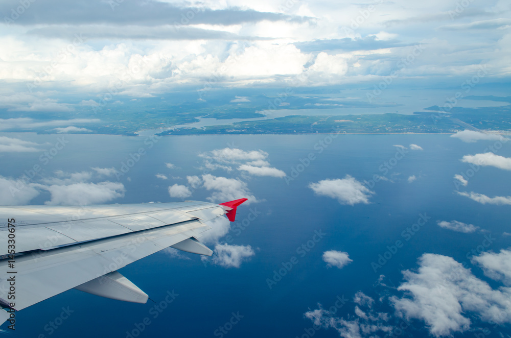 Fototapeta premium Beautiful Blue Sky Background and White Cloud by Take a Picture Through Window of an Aircraft during Flight in Wing.