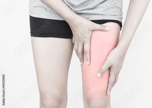 Young woman massaging her painful thigh muscles from exercising and running.