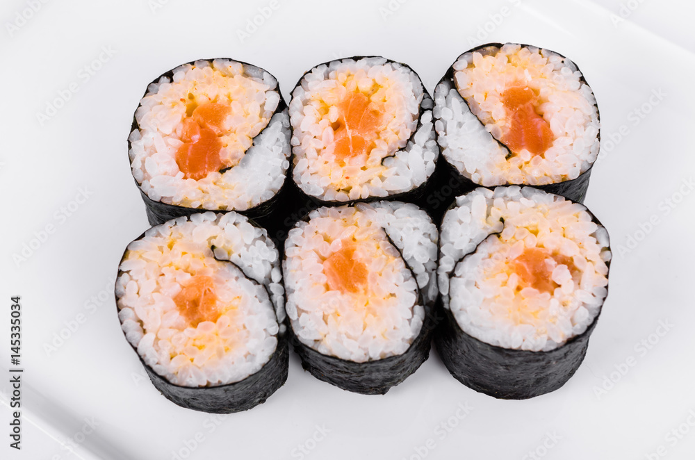 Asia. Spicy rolls with salmon (red fish) on a white plate on a white background Asia. Spicy rolls with salmon (red fish) on a white plate on a white background