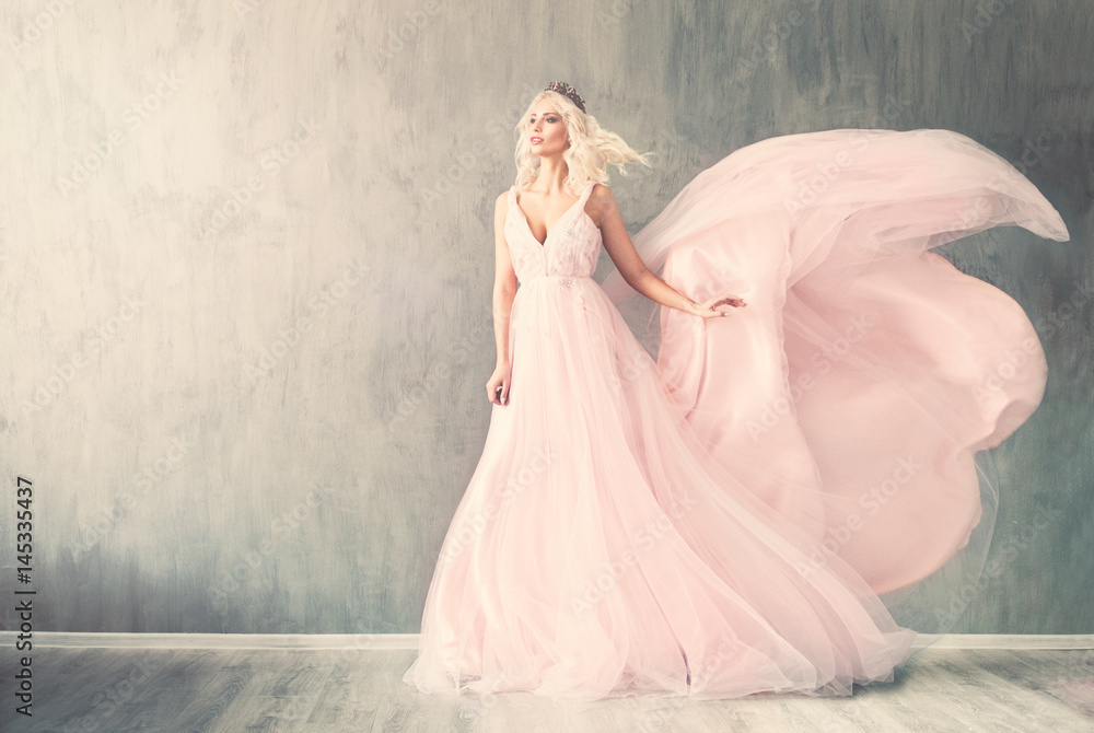 Friendly Woman Fashion Model in Pink Dress on Blue Background with Copy space Friendly Woman Fashion Model in Pink Dress on Blue Background with Copy space