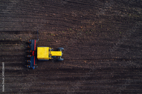 Aerial view of tractor working on the harvest field