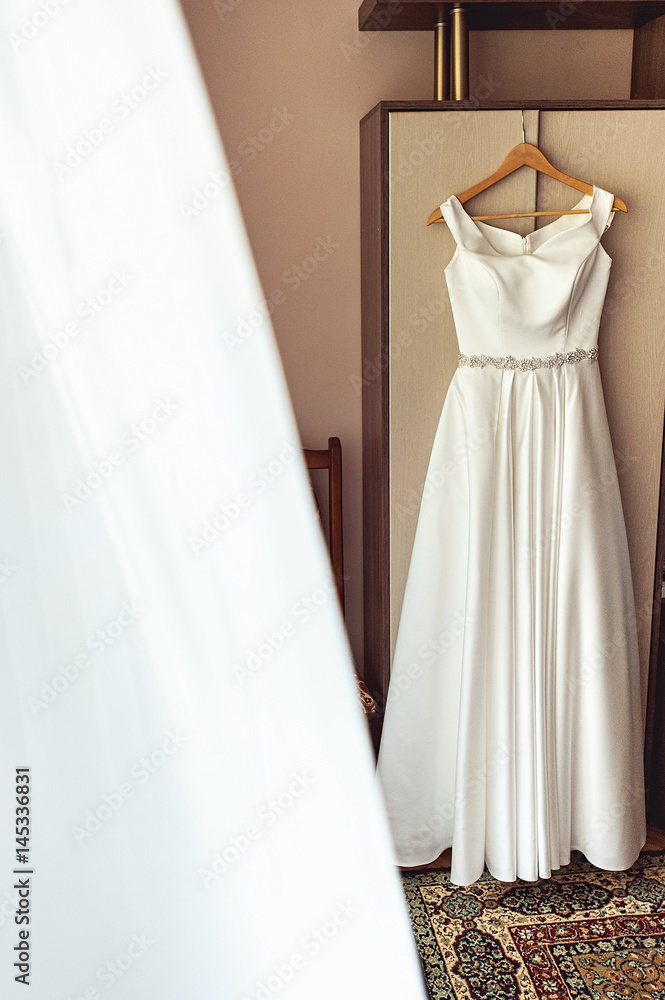 Simple white wedding dress on the rack at the wardrobe Simple white wedding dress on the rack at the wardrobe