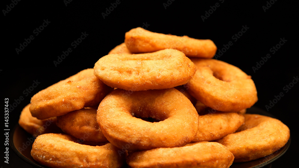 Pile of a doughnuts on a black dish