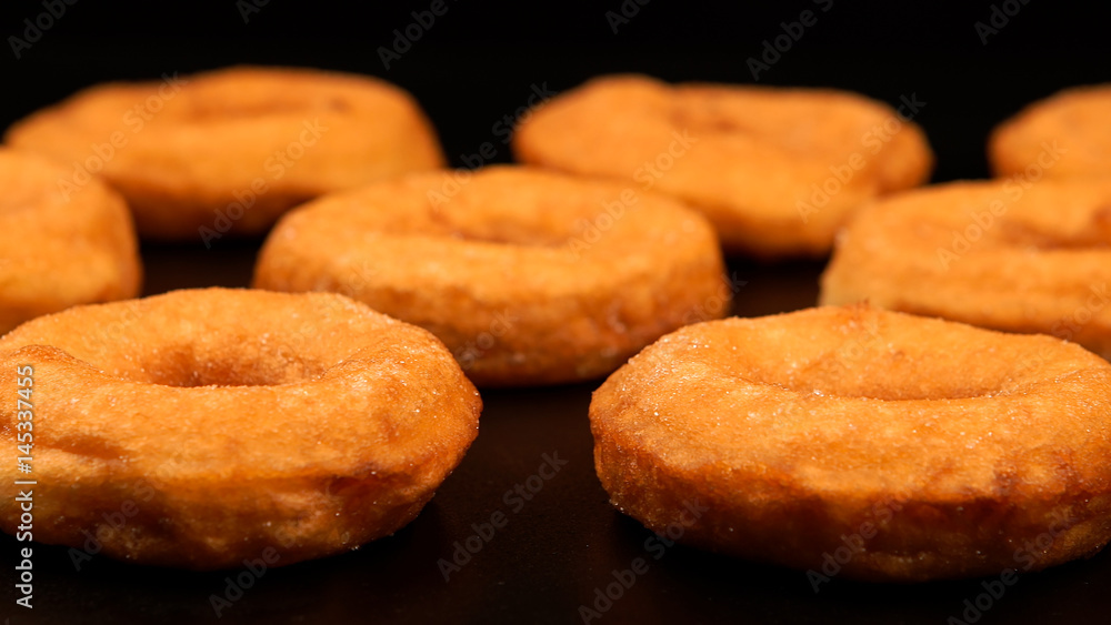 Rows of fried doughnuts on the black table Rows of fried doughnuts on the black table