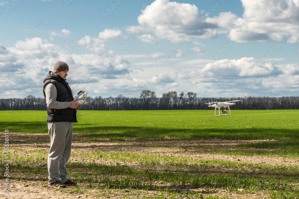 man operating of flying drone quadrocopter at the green field man operating of flying drone quadrocopter at the green field