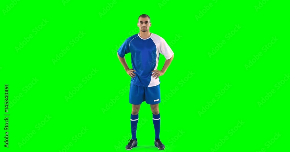 Confident football player standing against green screen Confident football player standing against green screen