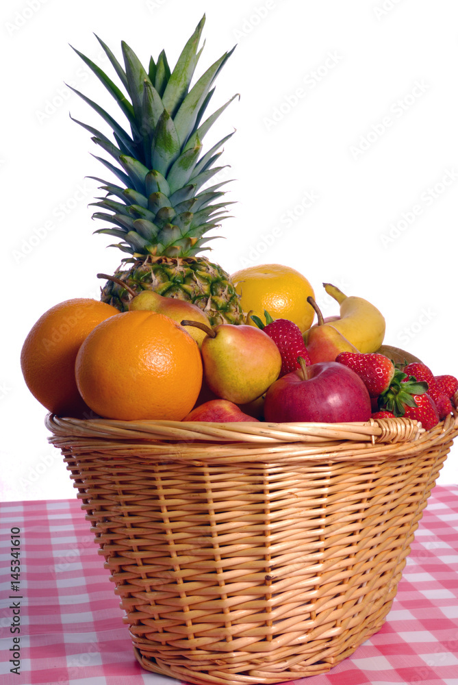 Basket full of various kinds of fruit with red rustic table cloth over white background Basket full of various kinds of fruit with red rustic table cloth over white background