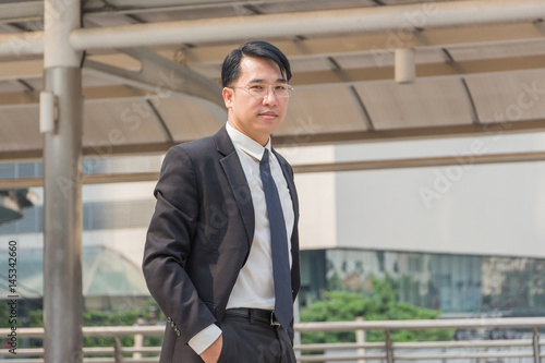 Close up of young business man standing standing with hands in pocket over blurry background with copy space for concept picture.