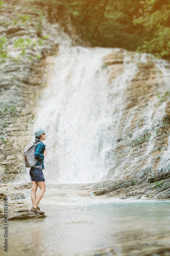 Explorer girl looking at waterfall.
