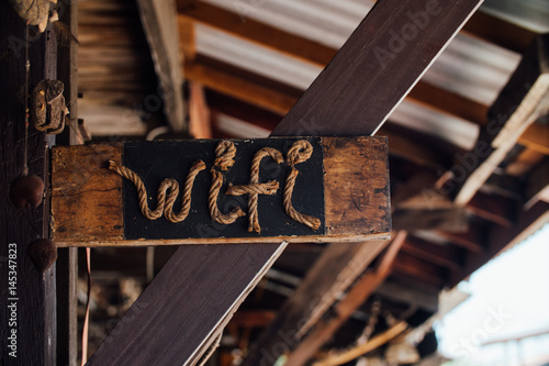 Cute vintage sign of a wi-fi from a rope in black wooden signboard in. photo