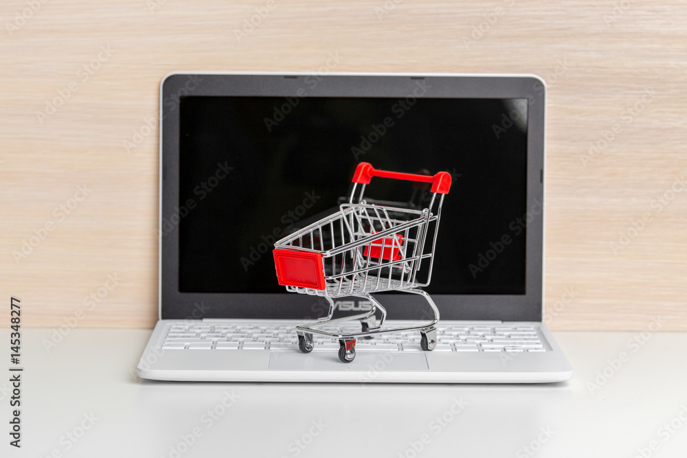 Shopping Cart On Laptop At Wooden Table