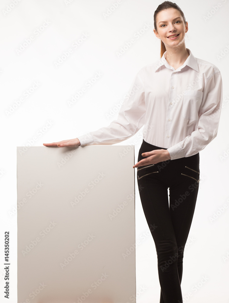 Young happy woman showing presentation, pointing on placard over gray background Young happy woman showing presentation, pointing on placard over gray background