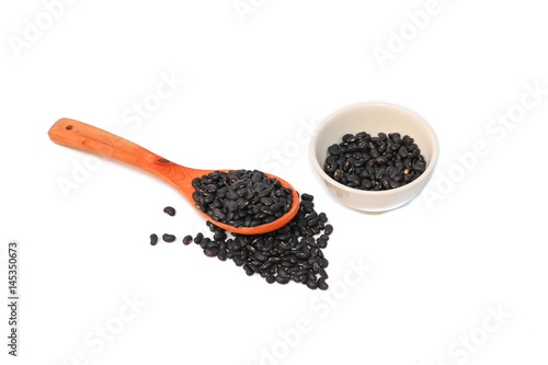 black beans with wooden spoon and in cup  on white background view from above
