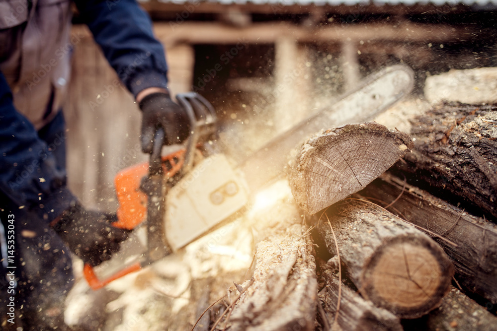 Chainsaw in action cutting wood. Man cutting wood with saw, dust and movements. Chainsaw in action cutting wood. Man cutting wood with saw, dust and movements.