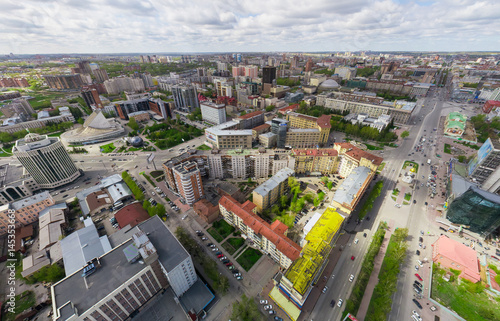 Aerial city view with crossroads and roads  houses  buildings  parks and parking lots  bridges. Copter shot. Panoramic image.