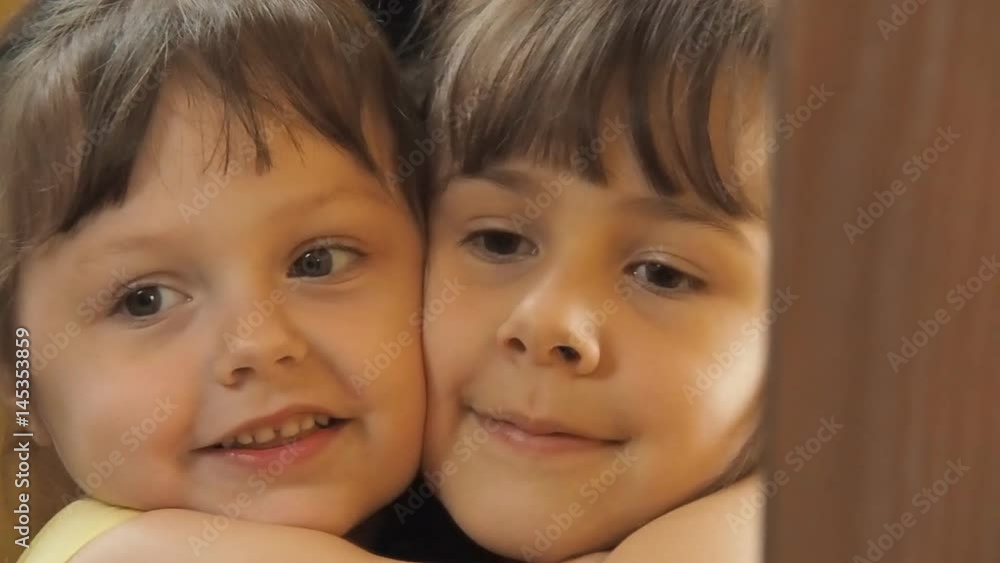 Children in front of the mirror. Sisters are hugging. Dust on the mirror. Little girls in front of a mirror. Slow motion. Children in front of the mirror. Sisters are hugging. Dust on the mirror. Little girls in front of a mirror. Slow motion.