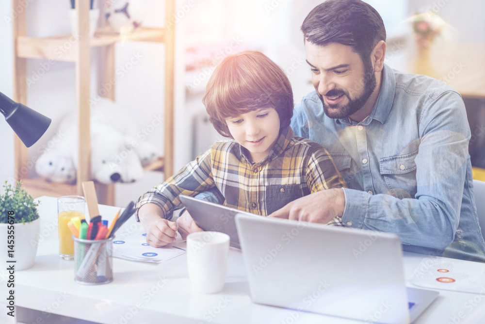 Father and son looking at digital tablet Father and son looking at digital tablet