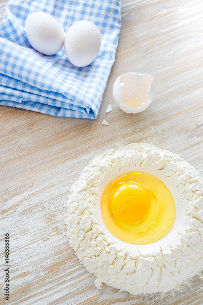 Ingredients and tools for baking - flour, eggs and glass of milk on the wooden rustic table background, selective focus Ingredients and tools for baking - flour, eggs and glass of milk on the wooden rustic table background, selective focus