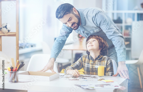 Cheerful father standing behind little son