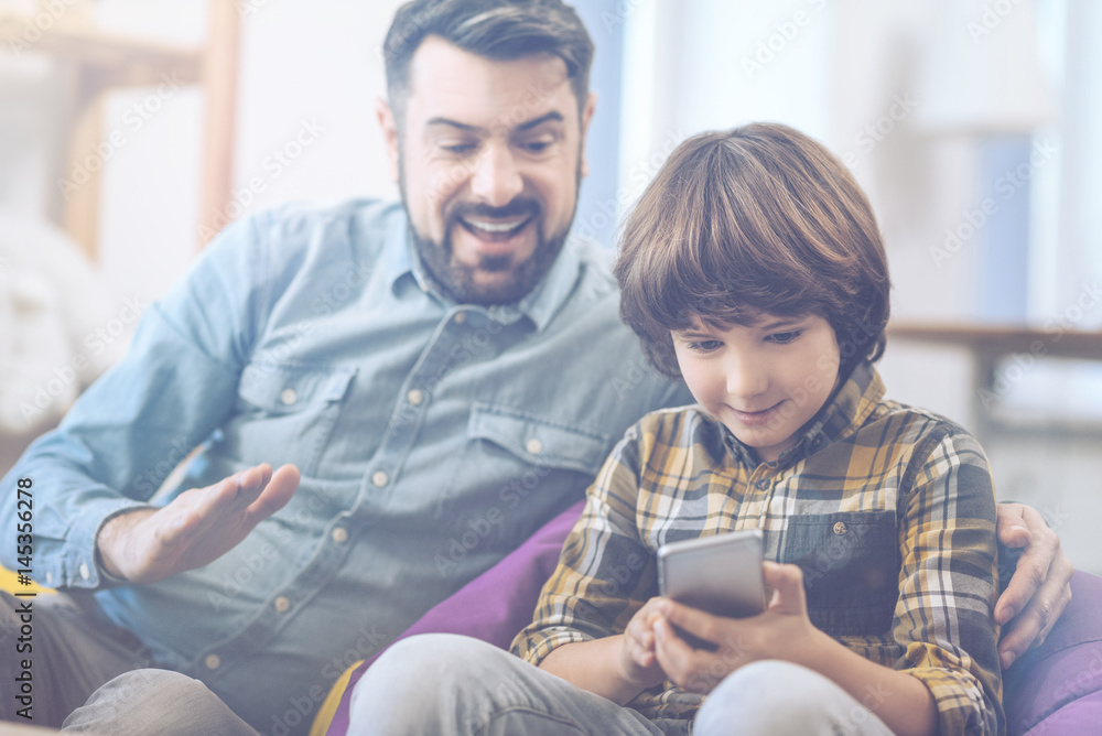Father and son playing on smartphone Father and son playing on smartphone