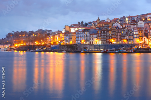 Ribeira and Old town of Porto with mirror reflections in the Douro River during evening blue hour, Portugal, Portugal.