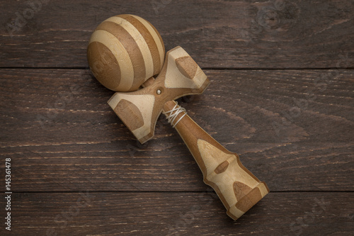 Принти на полотні Brown kendama laying on a dark wooden antique background