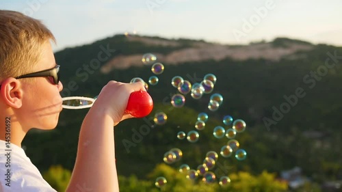 The boy is making soap bubbles. Close-up. Panoramic view photo