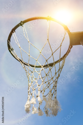 Кольцо для баскетбол крупным планом в лучах солнца, закат небо. дворовая игра, лига, чемпионат.