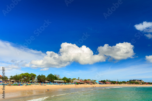 Tropical beach island bali, on background blue sky, sandy beach and sea water on horizon. Jimbaran beach Bali, Indonesia photo