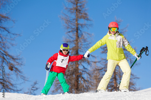 Portrait of active family skiing holding hands