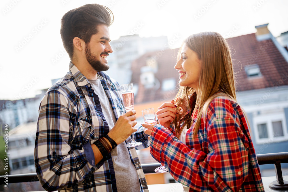 Young couple having party on apartment balcony drinking champagne Young couple having party on apartment balcony drinking champagne