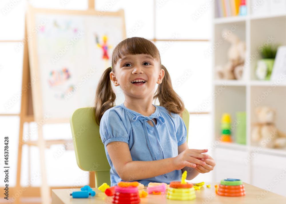 Child playing plasticine in kindergarten. Child playing plasticine in kindergarten.