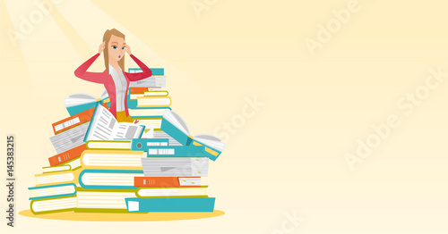 Student sitting in huge pile of books.