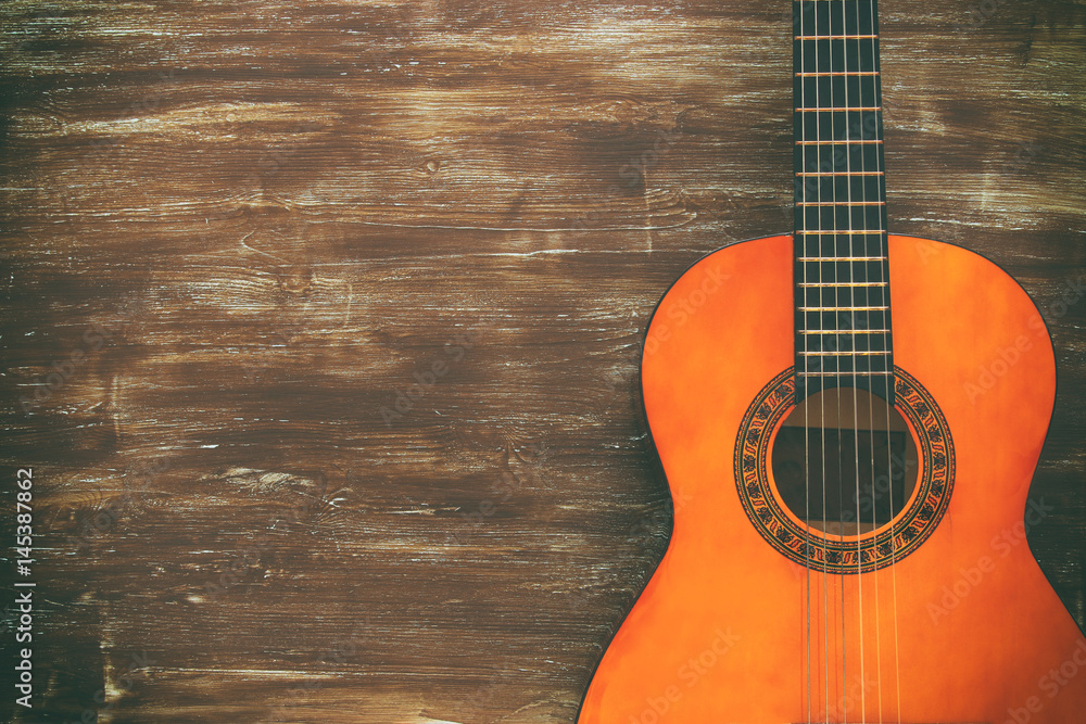 Obraz premium Close up of acoustic guitar against a wooden background