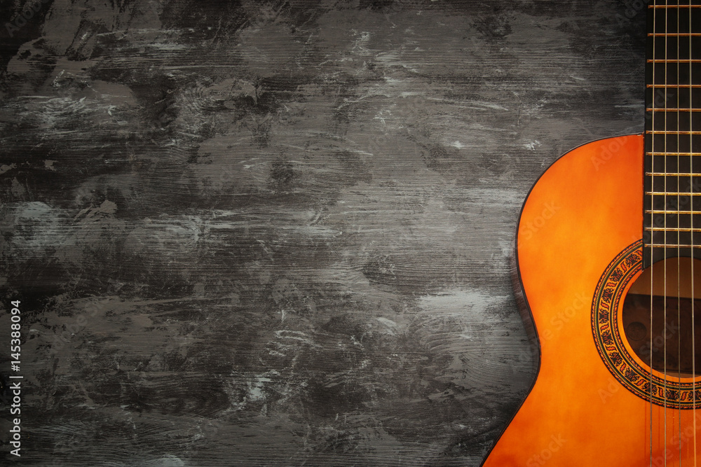 Fototapeta premium Close up of acoustic guitar against a wooden background