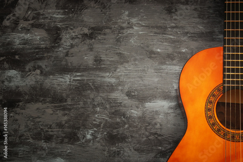 Close up of acoustic guitar against a wooden background