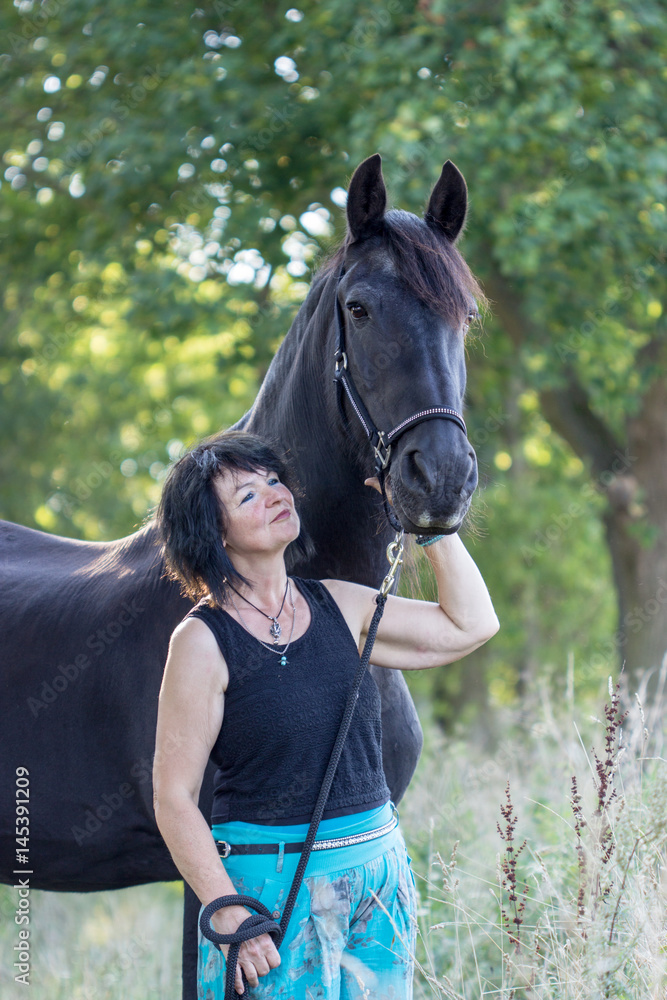 Obraz premium woman and horse / Brunette woman with black horse in forest 