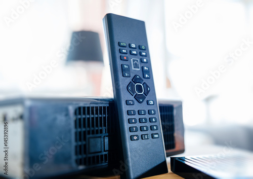 Small remote control next to wireless tv box used for TV Internet Telephone communication via fiber optic or coaxial cable  photo