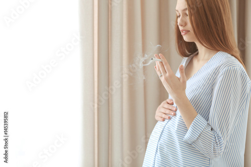 Pregnant woman smoking ciga...