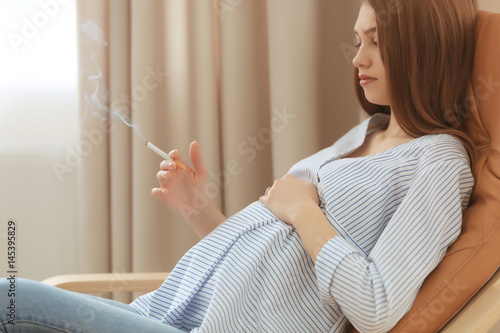 Pregnant woman smoking ciga...