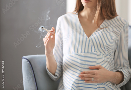 Pregnant woman smoking ciga...