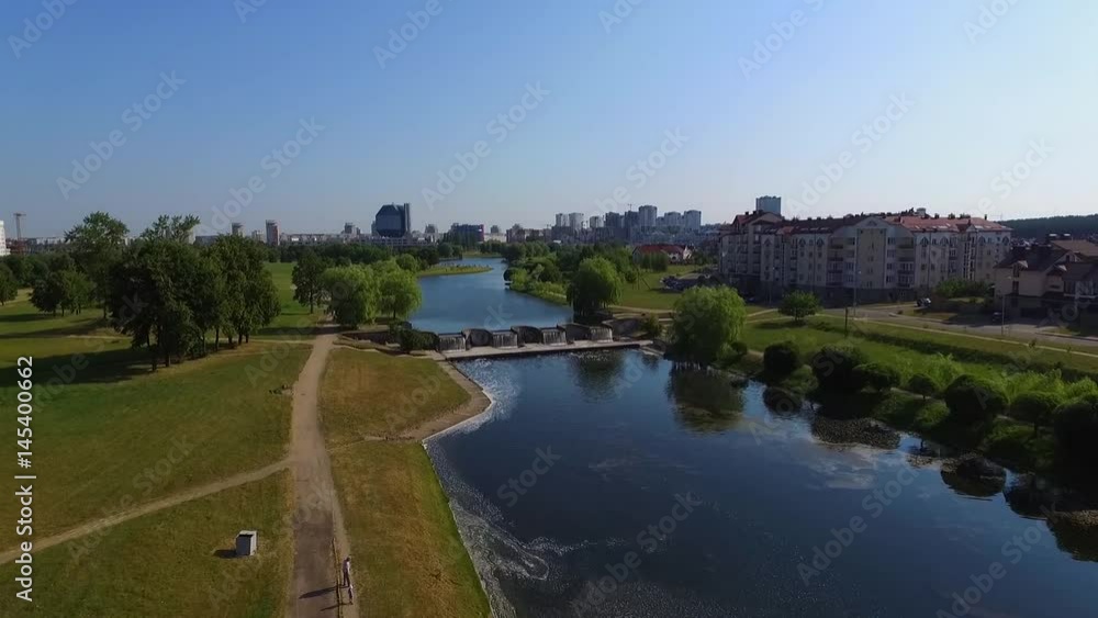 The drone is flying over the lake in the city. The drone is flying over the lake in the city.