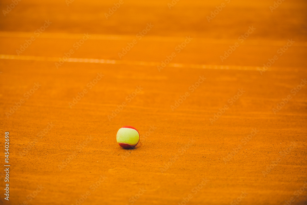 tennis red ball on a clay tennis court orange color
