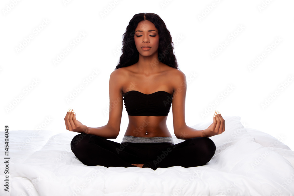 Fotografie Beautiful woman sitting in lotus yoga pose on bed