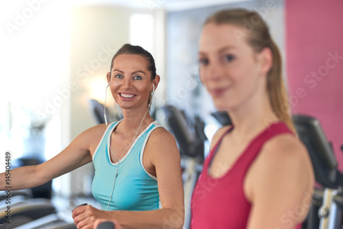 Frau mit Kopfhörern auf dem Laufband