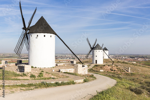 white windmills and a view of Alcazar de San Juan town, province of Ciudad Real, Castilla-La Mancha, Spain