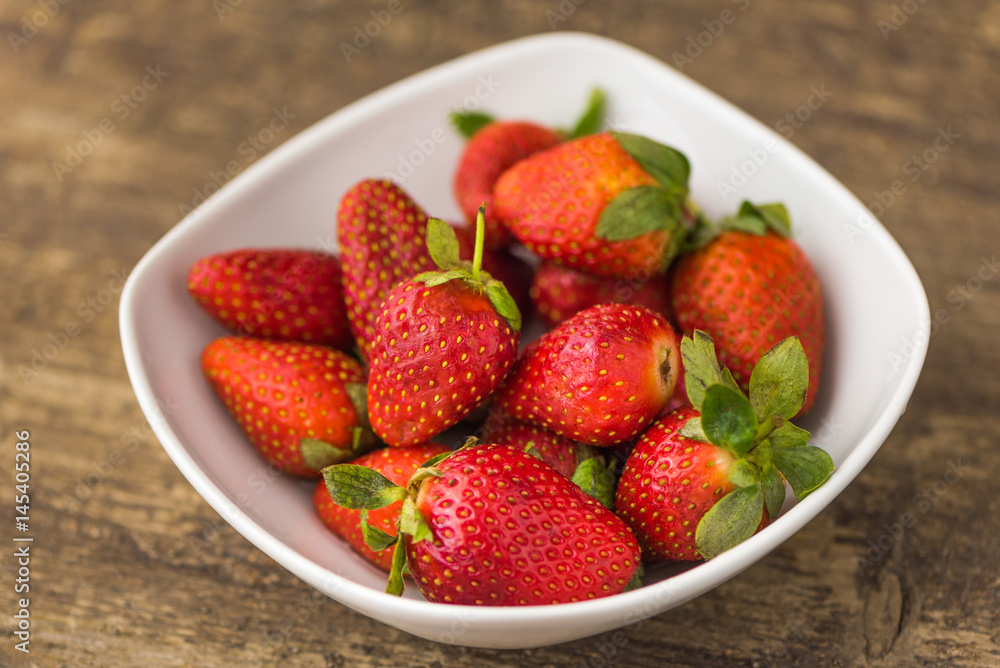 Freshly Handpicked Strawberries in a Bowl on Wooden Table Freshly Handpicked Strawberries in a Bowl on Wooden Table